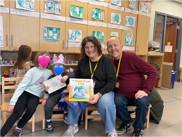 Matt and Kelsey reading with their daughter at school